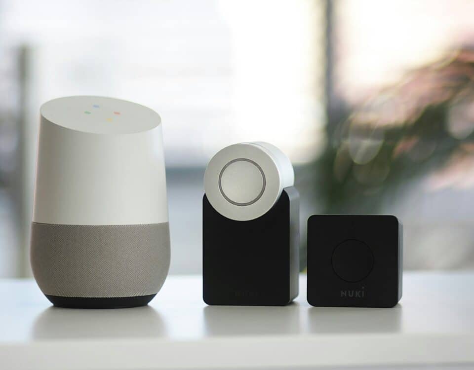 white and gray Google smart speaker and wo black speakers